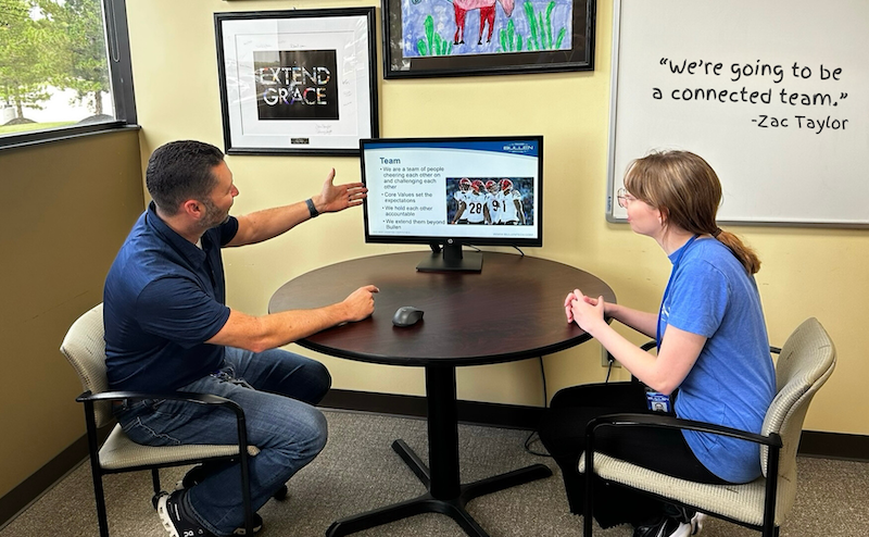 bullen manager speaking with employee at computer
